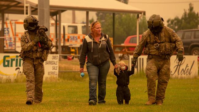 Australian army personnel help residents evacuate from Omeo in Victoria during Operation Bushfire Assist in 2019-20.