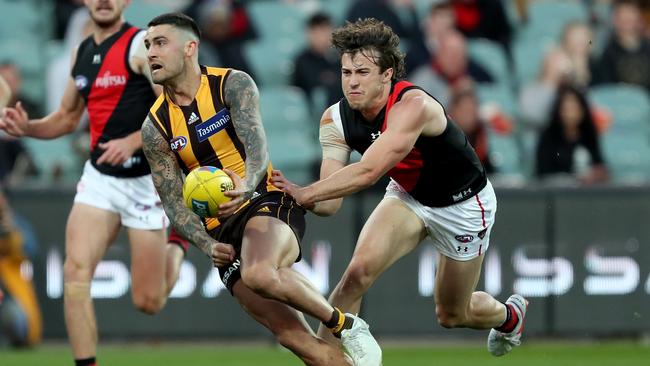 Hawk Chad Wingard tries to evade Bomber Andrew McGrath during Thursday’s match at Adelaide Oval. Picture: James Elsby/AFL Photos via Getty Images