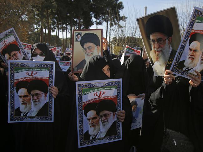 In this photo provided by Tasnim News Agency, women hold posters showing portraits of late Iranian revolutionary founder Ayatollah Khomeini, and Supreme Leader Ayatollah Ali Khamenei during a pro-government rally in the holy city of Qom, Iran, Wednesday, Jan. 3, 2018. Tens of thousands of Iranians took part in pro-government demonstrations in several cities across the country on Wednesday, Iranian state media reported, a move apparently seeking to calm nerves after a week of protests and unrest that have killed at least 21 people. (Mohammad Ali Marizad/Tasnim News Agency via AP)