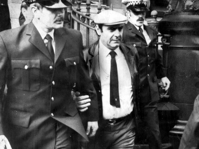 Gianfranco Tizzoni surrounded by police as he leaves the Victorian Supreme Court after his arrest in 1983.