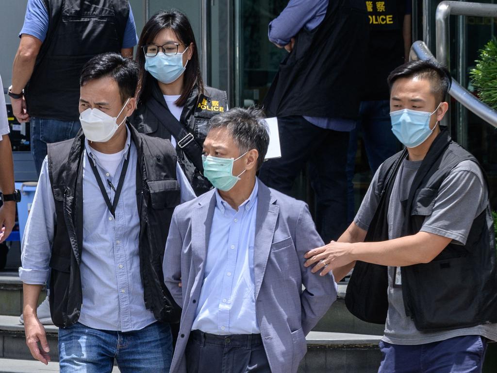 Apple Daily Chief Operations Officer Chow Tat Kuen (2nd R) is escorted by police to a waiting vehicle from the offices of the local Apple Daily newspaper in Hong Kong.