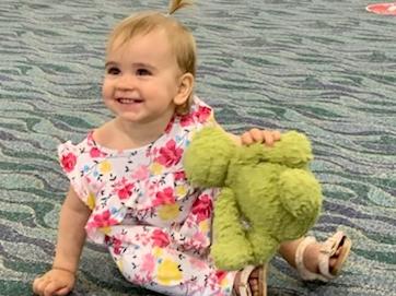 Mia Evans, 15 months, was reunited with Dino the green fluffy dinosaur at Townsville Airport after he was left on a Virgin Australia fight.