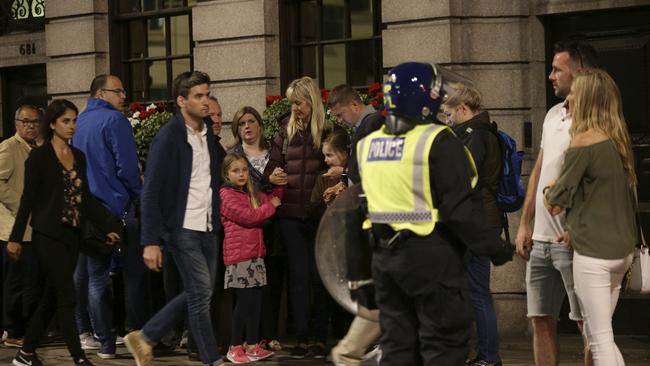 Guests from the Premier Inn Bankside Hotel are evacuated and kept in a group with police on Upper Thames Street following an incident in central London. Picture: PA via AP