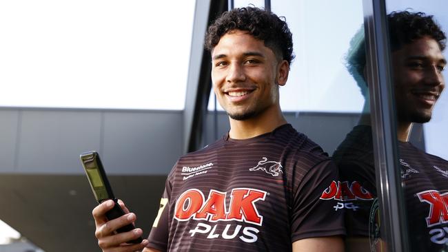 Izack Tago with his flip phone. The Panthers player is bucking the trend and staying off the internet. Picture: Jonathan Ng