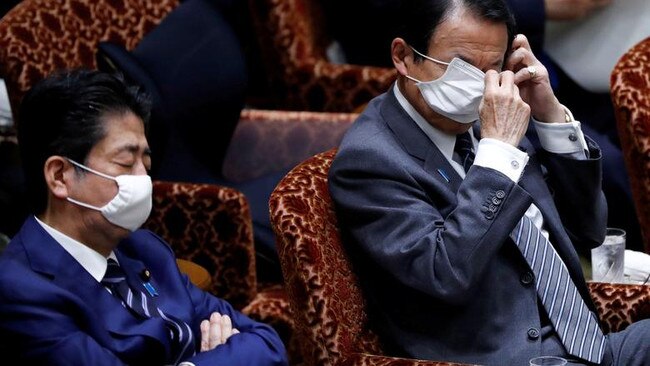 Shinzo Abe, left, rests his eyelids next to Finance Minister Taro Aso in the Diet this week. Picture: Reuters