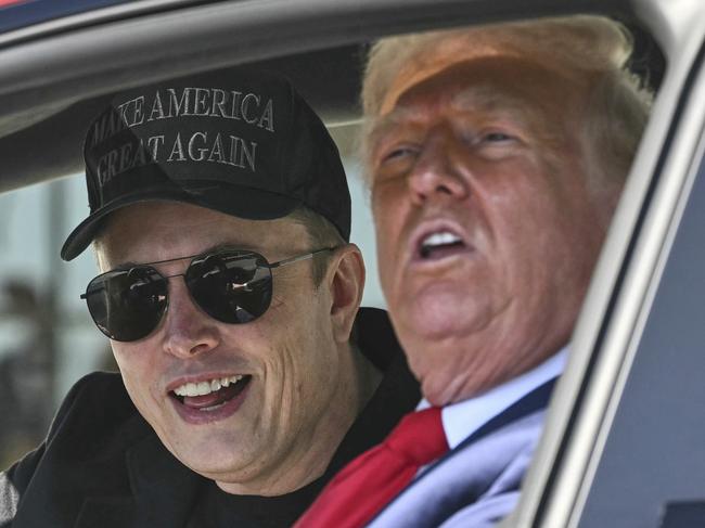 President Donald Trump and Tesla CEO Elon Musk speak to reporters as they sit in a Tesla vehicle on the South Lawn of the White House Tuesday, March 11, 2025, in Washington. (Pool via AP)