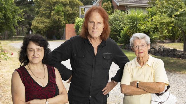 Neighbours Carol, Andrew and Peggy — who has lived in the street for 56 years — standing in front of one of the disputed properties. Picture: Ellen Smith