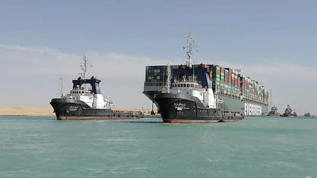 A picture released by Egypt's Suez Canal Authority shows a tugboat pulling the Panama-flagged MV 'Ever Given' container ship after it was fully dislodged from the banks of the Suez.