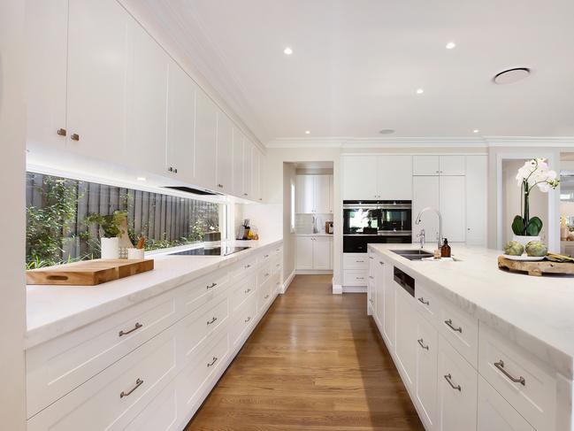 The kitchen is very stylish and full of storage.