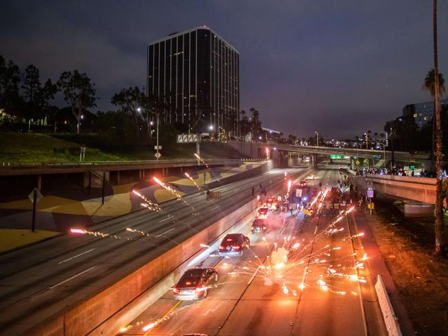 Demonstrators lights fireworks while they shut down the Freeway 110 North in downtown Los Angeles. Picture: Getty