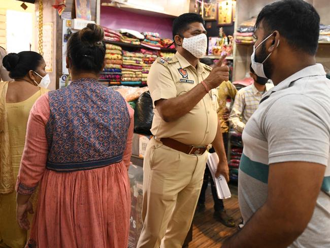 A police personnel (C) orders shopkeepers to shut a shop as a lockdown was imposed to curb the spread of COVID in Amritsar. Picture: AFP