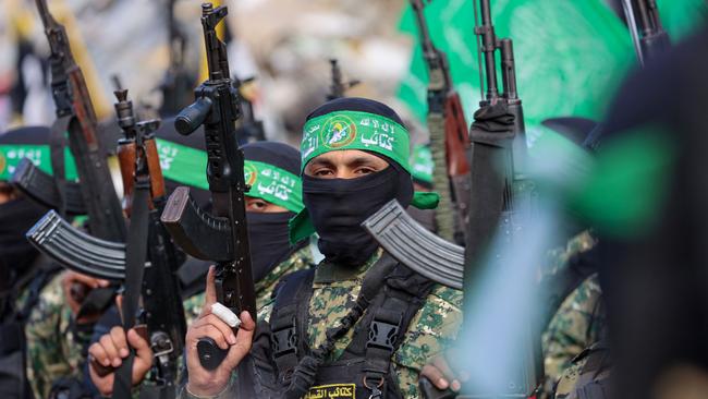 Hamas fighters secure an area in a square before handing over four Israeli hostages to a Red Cross team in Gaza City. Picture: AFP