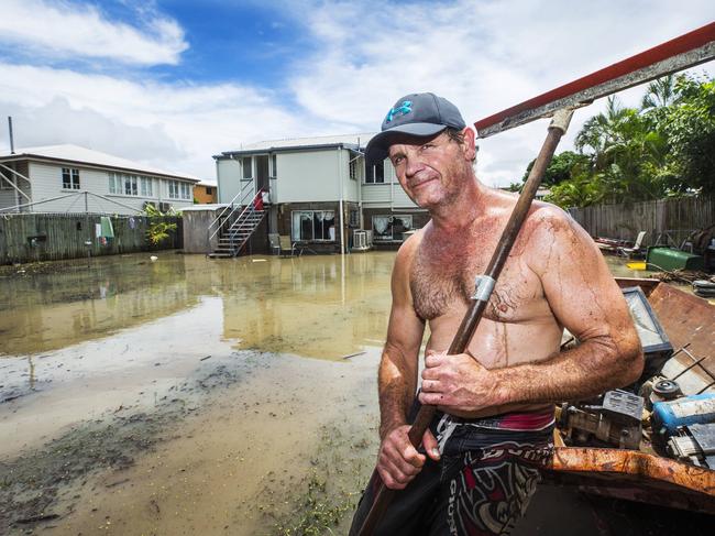 Railway Estate resident Johnny Brock attempting to clean up his flood ridden property which proved troublesome as flood waters again rose on Wednesday. Picture: Lachie Millard