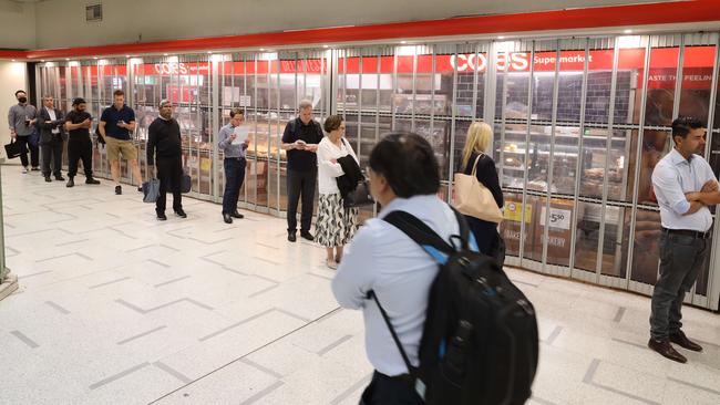 The Streets of Sydney on Monday morning with a looming shutdown due to the coronavirus. A queue at Coles supermarket at Wynyard station has a line of people waiting to get in at 8am. Picture: David Swift