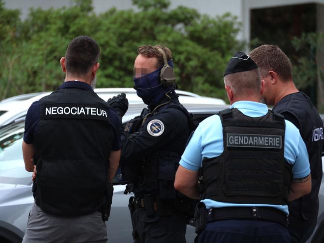 Special forces negotiators (L and R) flanked by a French gendarme officer of the elite police tactical unit of Orange "GIGN" (Groupe d'intervention de la Gendarmerie nationale - National Gendarmerie Intervention Group) (2nd L) and a French gendarme operate at the site of a fire and explosion of cars at a synagogue in La Grande-Motte, south of France, on August 24, 2024. At least two cars, one containing a gas bottle, were set alight on the morning of August 24, 2024, in front of the synagogue in La Grande-Motte, causing an explosion that injured a local policeman, the French gendarmerie and the town's mayor said. (Photo by Pascal GUYOT / AFP)