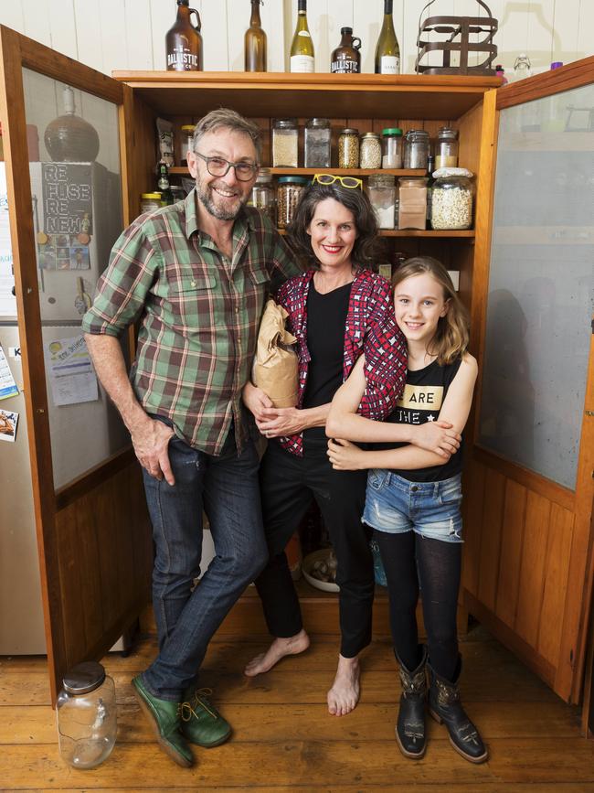 Rob Pekin with partner Emma-Kate Rose and daughter Elsie 9, at home in their kitchen at Salisbury in front of their bulk food pantry. Picture: Lachie Millard