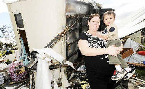 Alison Kaihhau and her 22-month-old son Tane of Kyogle with demolished caravan owned by Alison’s parents, also of Kyogle. . Picture: Jay Cronan