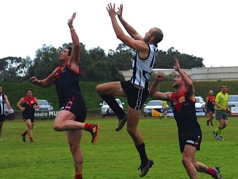 Kyneton recruit James Orr (centre) flies for a mark with Boort. Picture: Allan Fawcett