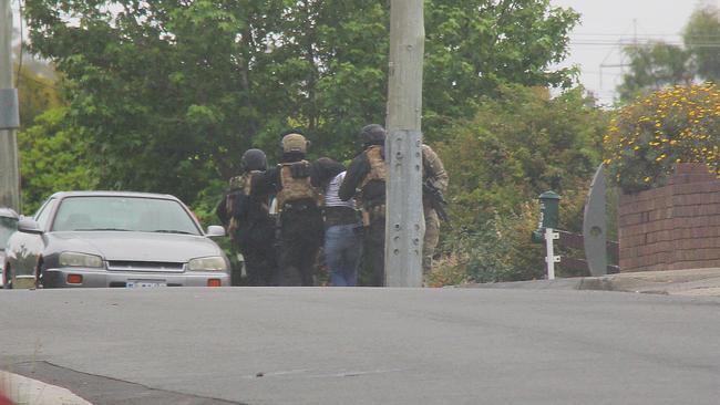 Brett Julian Robinson-Stacey is led away by police after the siege. Picture: BRUCE MOUNSTER