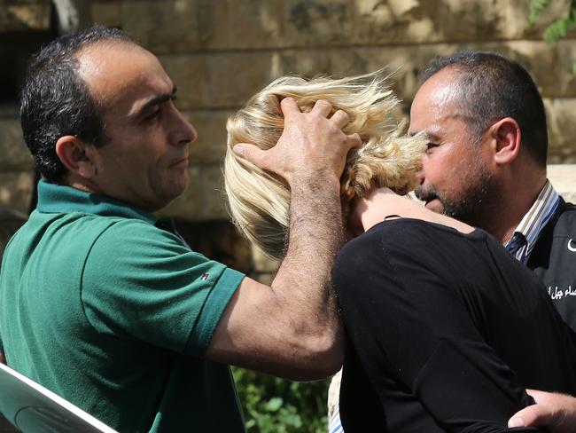 Police prevent Tara Brown from looking towards journalists. Picture: AP/Hussein Malla.