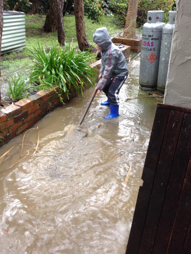 A young resident does his bit during flooding at Verdun. Picture: Mark Baryczka