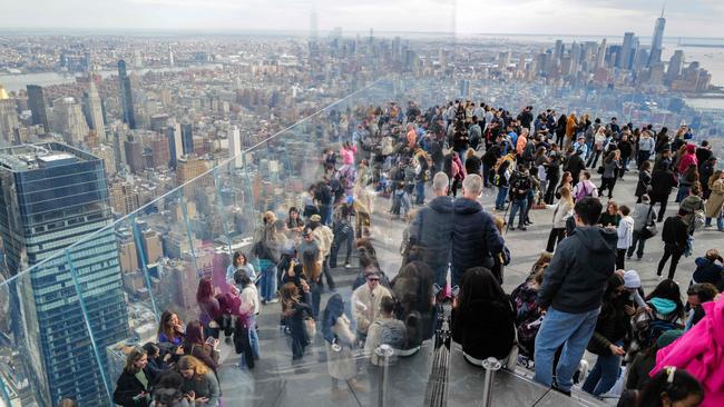 People gather at the 'Edge at Hudson Yards' observation deck to watch the total solar eclipse moving across New York City. Business capitalised on the event with special events and bookings. Picture: Charly Triballeau / AFP