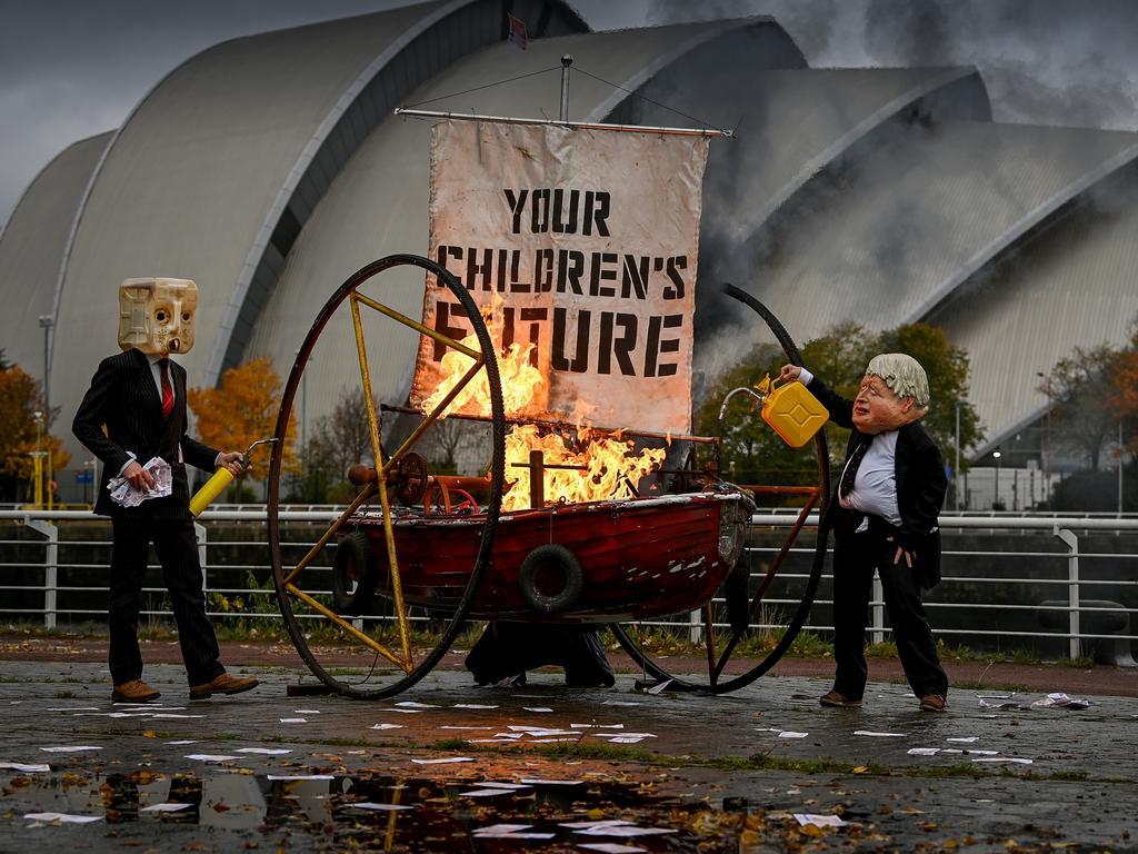 Activists from Ocean Rebellion dressed as Boris Johnson and an Oilhead set light to the sail of a small boat as they protest next to the River Clyde opposite the COP26 site. Picture: Jeff J Mitchell/Getty Images