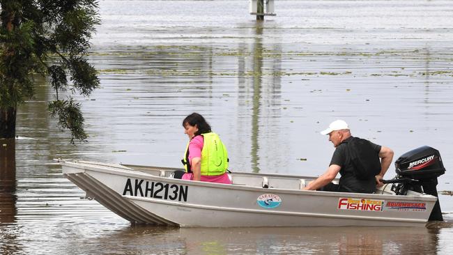 A family steers their boat through a flooded street in a residential area of Lawrence. Photo: SAEED KHAN / AFP