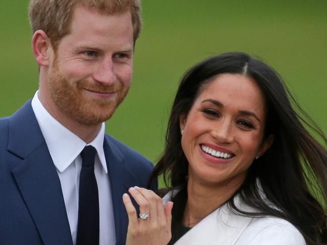 (FILES) This file photo taken on November 27, 2017 shows Britain's Prince Harry standing with his fiancée US actress Meghan Markle as she shows off her engagement ring whilst they pose for a photograph in the Sunken Garden at Kensington Palace in west London, following the announcement of their engagement. With less than five months to go until the May 19 wedding of Britain's Prince Harry and US actress Meghan Markle in the mediaeval castle's chapel, the local authority's bid to sweep the homeless off the streets has triggered indignation. / AFP PHOTO / Daniel LEAL-OLIVAS