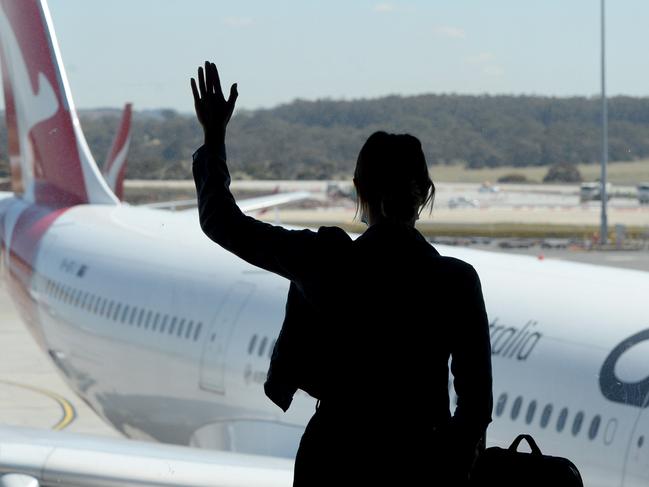 MELBOURNE, AUSTRALIA - NewsWire Photos NOVEMBER 22, 2021: A passenger farewells the first QANTAS international flight from Melbourne with a plane leaving for Singapore. Picture: NCA NewsWire / Andrew Henshaw