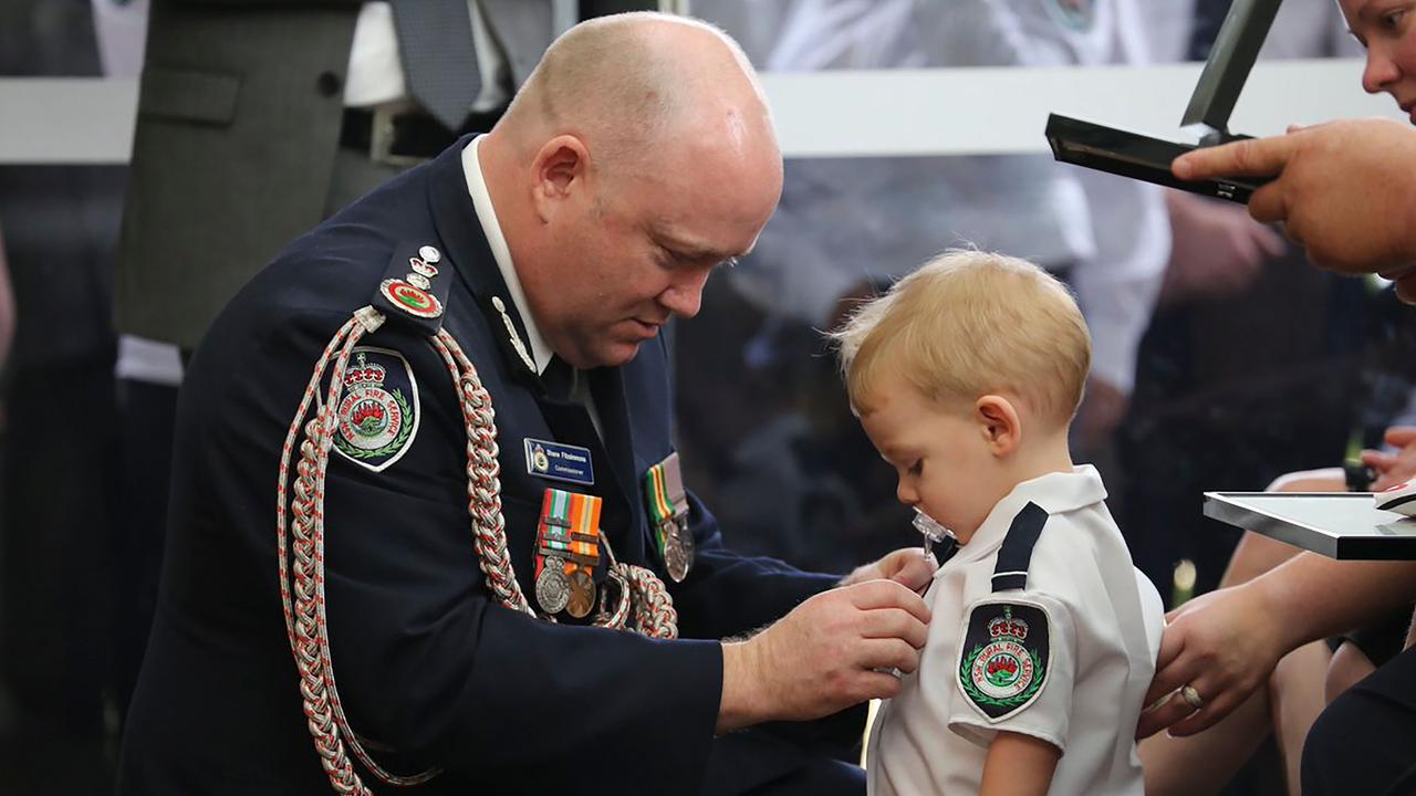 NSW RFS Commissioner Shane Fitzsimmons (L) pinning a medal on Harvey Keaton, the son of Geoffrey Keaton, last week. Picture: NSW RFS