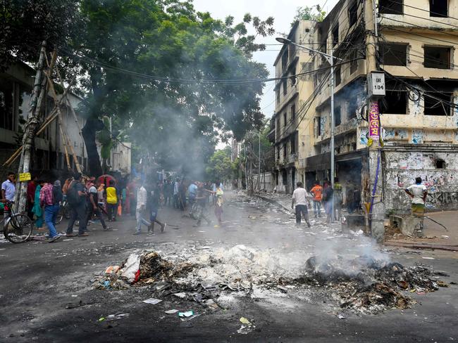 TOPSHOT - Smoke billows near burnt Awami League party office as anti-government protestors set fire in Dhaka on August 6, 2024, after former prime minister Sheikh Hasina fled the country. Student leaders in Bangladesh demanded on August 6 Nobel winner Muhammad Yunus lead a caretaker government, a day after the military took control as mass demonstrations forced longtime ruler Sheikh Hasina to flee the country. (Photo by Munir Uz Zaman / AFP)