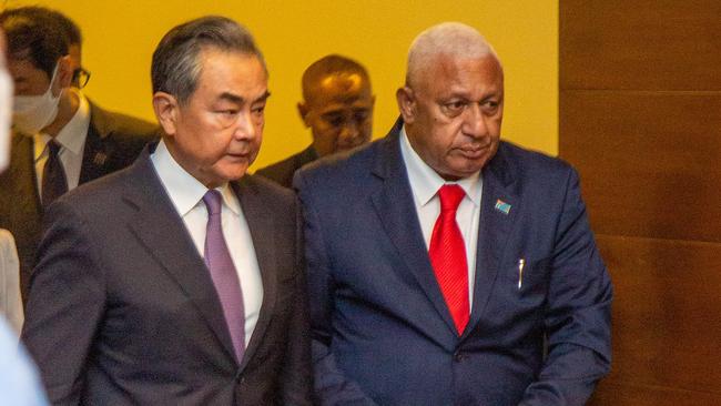 Chinese Foreign Minister Wang Yi (L) and Fijian Prime Minister Frank Bainimarama (R) arrive for a joint press conference in Suva. Picture: AFP.