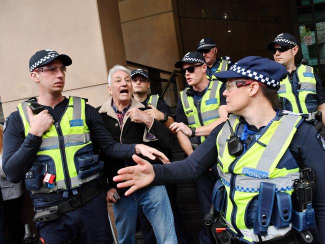 Police hold back the man. Picture: Jake Nowakowski