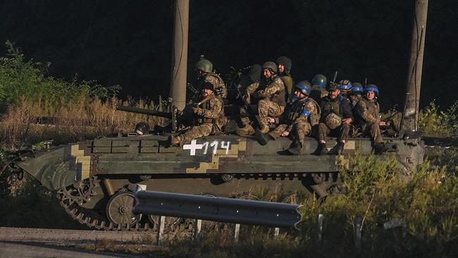 Ukrainian army's fighters sit on the top of an armed vehicle in kharkiv on Friday. Picture: AFP