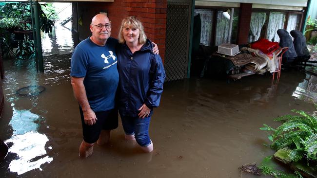 Kellee Wilson and husband Steven stand in the rising water that has flooded the lower level of their home in Regentville. Picture: Toby Zerna