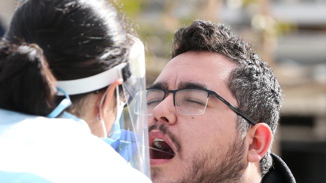 MELBOURNE, AUSTRALIA - JULY 02: A man gets a Covid-19 test at a testing site on July 02, 2020 in Melbourne, Australia. Lockdowns across Melbourne have come into effect for residents of suburbs identified as COVID-19 hotspots following a spike in new coronavirus cases through community transmission. From midnight Wednesday 1 July, residents of 10 postcodes will only be able to leave home for exercise or work, to buy essential items including food or to access childcare and healthcare. Businesses and facilities in these lockdown areas will also be restricted and cafes and restaurants can only open for take-away and delivery. The restrictions will remain in place until at least 29 July. (Photo by Asanka Ratnayake/Getty Images)