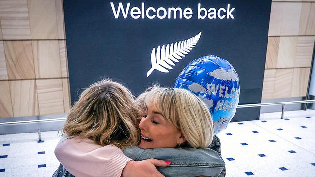 A passenger hugs family members upon arrival from New Zealand at Sydney International Airport. Picture: AFP