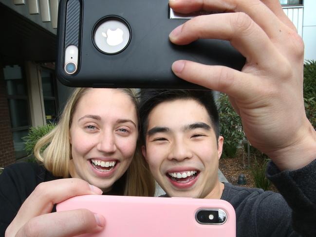 Aussies are spending hours on their phones. Hannah O'Brien 21, and Zi Kit Toh 22, can't be parted from their iPhones. Picture: David Caird