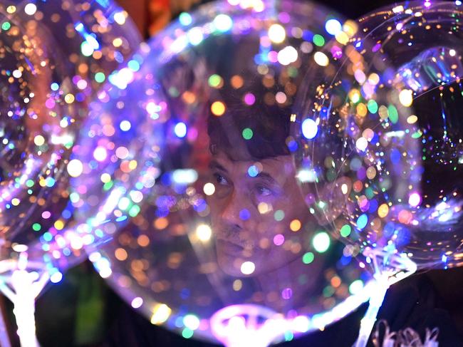 A man sells balloons as people attend a pre-dawn mass ahead of Christmas in Manila. Picture: Jam Sta Rosa/AFP