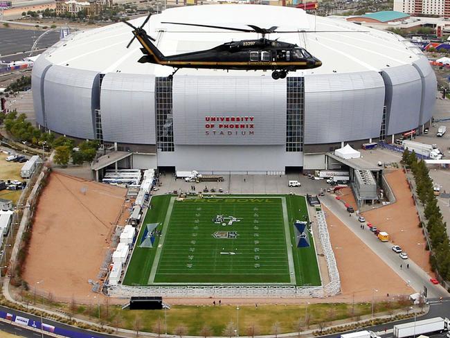 FILE- In this Monday, Jan. 26, 2015, file photo, with the grass field tray outside, a U.S. Customs and Border Protection Black Hawk helicopter circles above University of Phoenix Stadium, site of the NFL Super Bowl XLIX football game, during a security demonstration for the media in Glendale, Ariz. With a retractable roof and field that can been wheeled out into the sunlight, the stadium is unlike any other stadium in the world. (AP Photo/Ross D. Franklin, File)