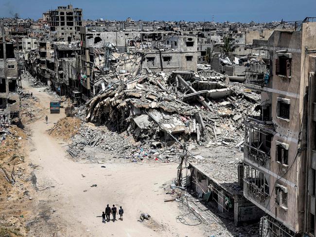 People walk past destroyed buildings in Khan Yunis in the southern Gaza Strip. Picture: AFP