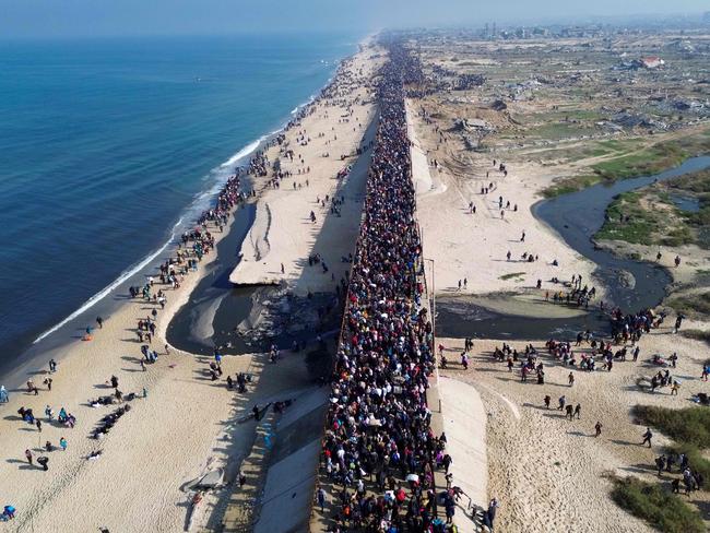 This aerial photo shows displaced Gazans walking toward Gaza City along the beautiful coastline following the ceasefire. Picture: AFP