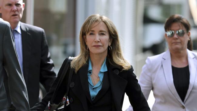 FILE - This April 3, 2019 file photo shows actress Felicity Huffman arriving at federal court in Boston to face charges in a nationwide college admissions bribery scandal. Huffman is facing a prison sentence after agreeing Monday to plead guilty to one count of conspiracy and fraud for paying a consultant $15,000 disguised as a charitable donation to boost her daughterâ€™s SAT score. Prosecutors are seeking four to 10 months of confinement, and experts different on whether the plea, and Huffmanâ€™s subsequent apology taking full responsibility for her actions, will lead to a career rebound or retreat. (AP Photo/Charles Krupa, File)