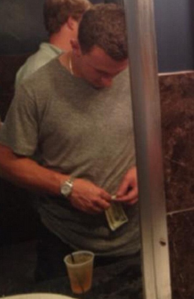 Johnny Manziel rolls a dollar bill. Picture: Busted Coverage