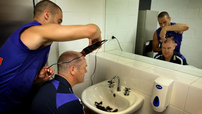 Defender Lindsay Gilbee cuts coach Rodney Eades hair before the team photo was taken. Picture: Michael Klein.