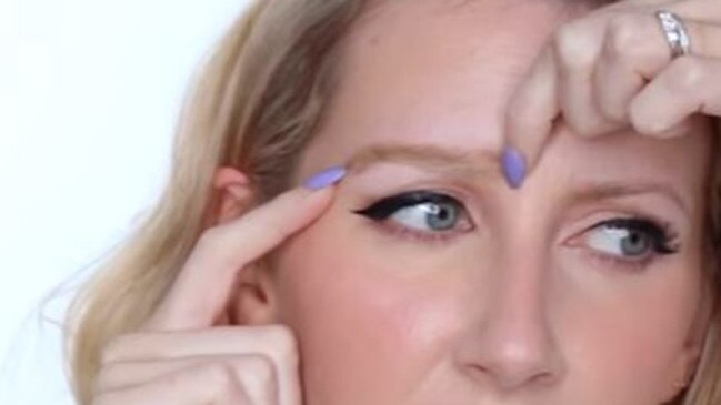 Makeup blogger Sharon Farrell applies an eyebrow wig.