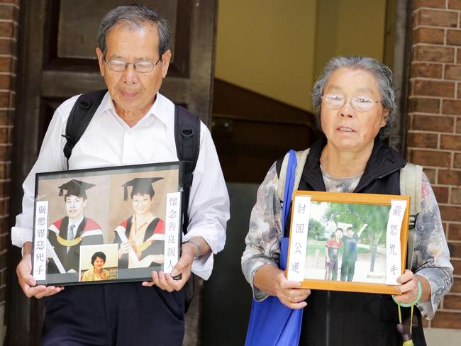 Grieving grandparents Yang Fei Lin and his wife Feng Qing Zhu holding pictures of their dead grandchildren. Picture: Christian Gilles