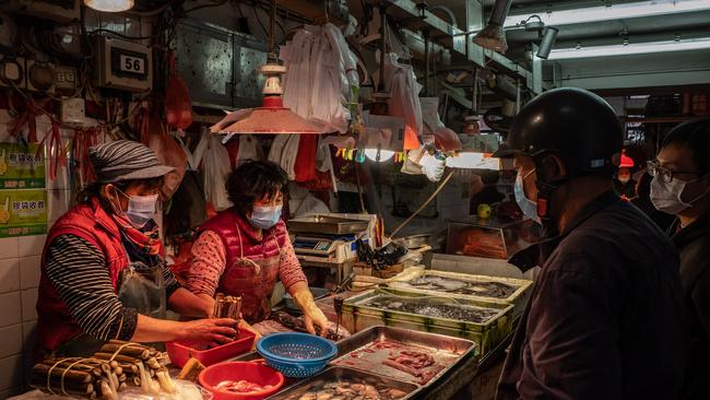 Residents wearing face mask purchase seafood at a wet market in Macau, China.