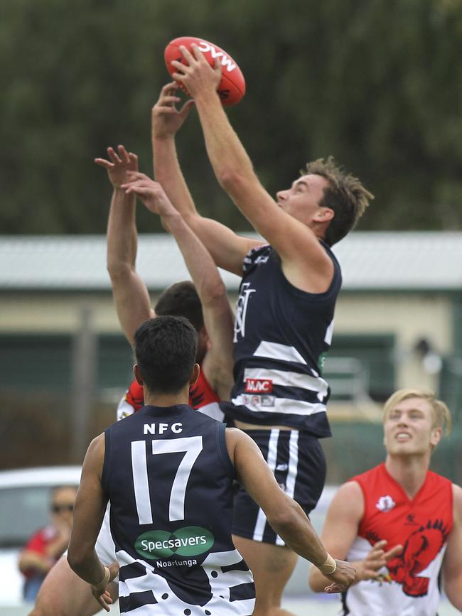 Noarlunga's Nick Mott takes a strong mark against Flagstaff Hill. Picture: AAP/Dean Martin